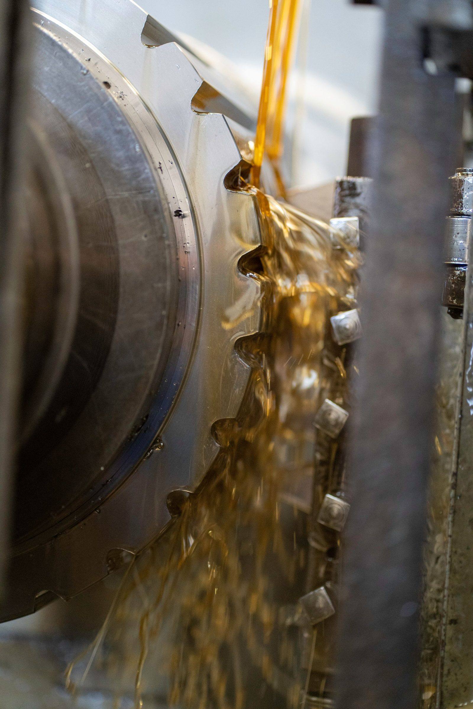 Clean amber oil flowing over machine gears