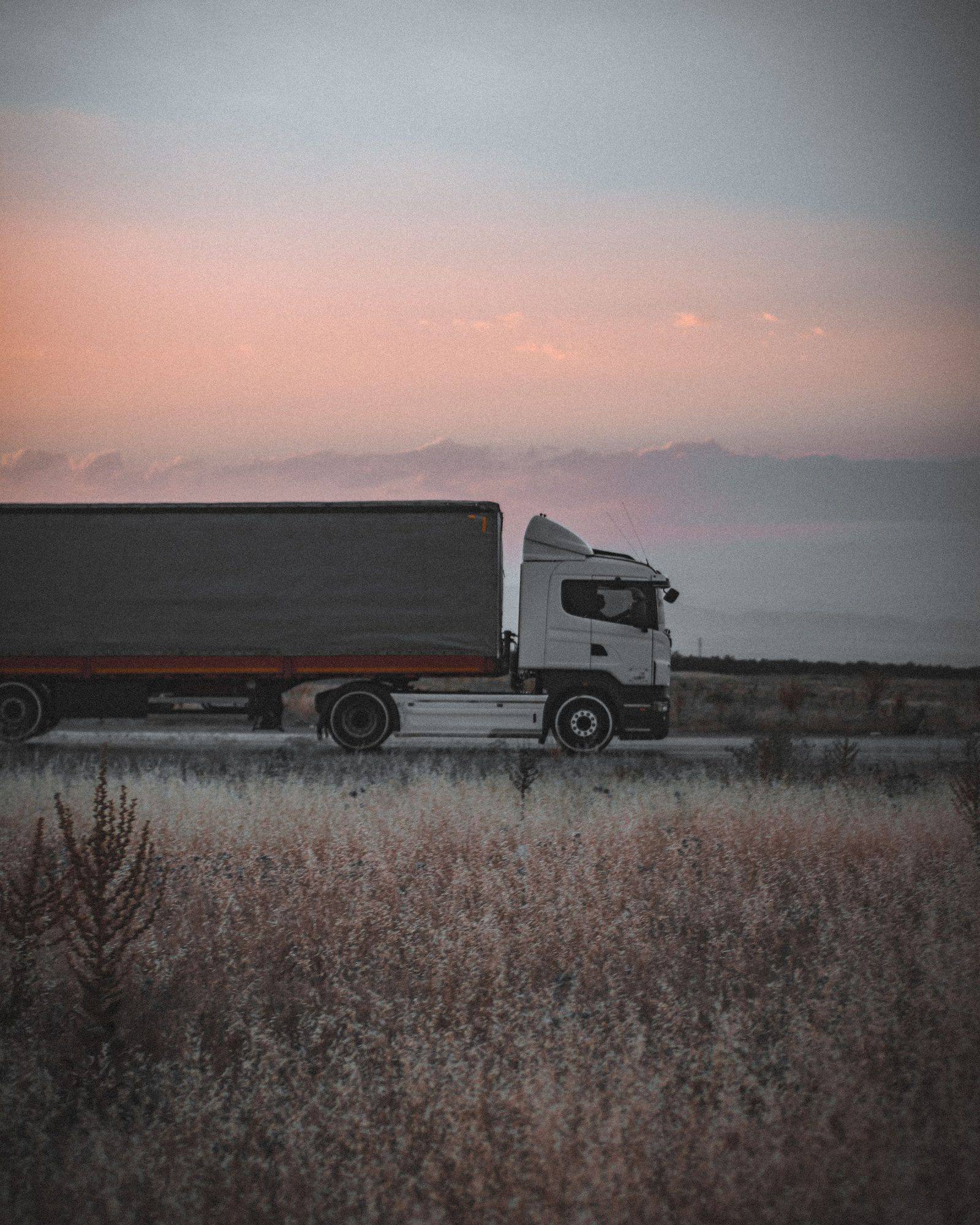 Heavy-duty truck on an open road at dusk